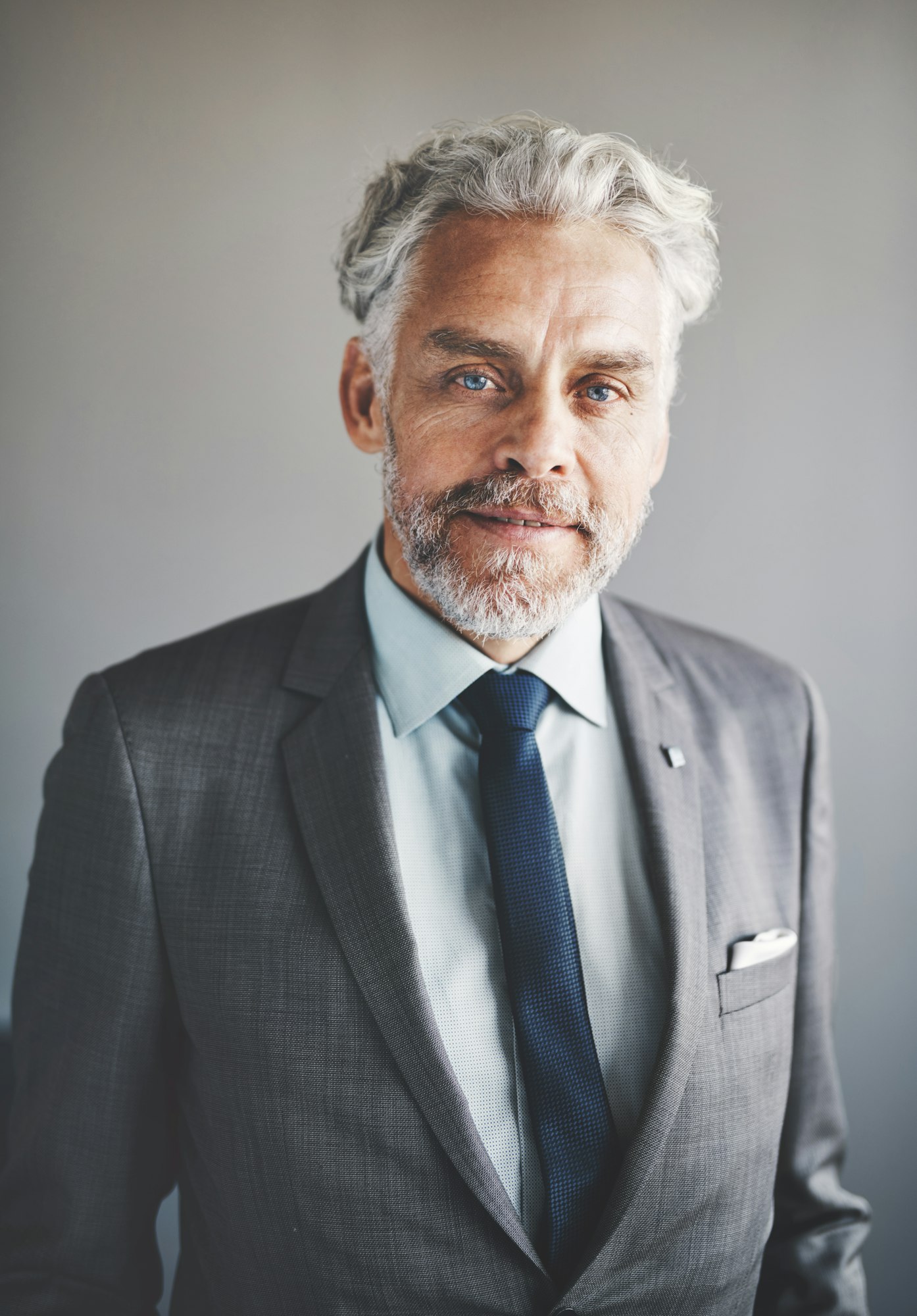 Confident mature businessmen wearing a suit standing in an office